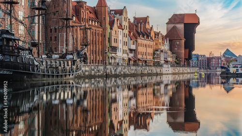 Amazing view of city Gdansk at sunrise. The oldest medival port crane (called Zuraw), a promenade along the riverbank of Motlawa River and ship.
 photo