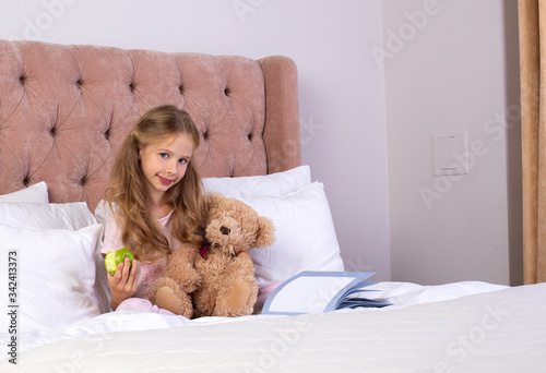 Little pretty girl read book in bedroom