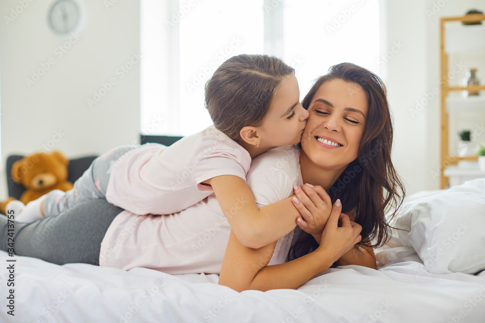 Happy mother's day.Portrait of happy mother and daughter lying on the bed at home. Happy mother's day.Portrait of happy mother and daughter lying on the bed at home.
