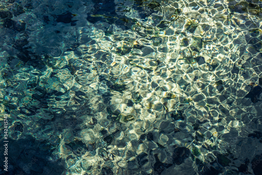Fototapeta premium Shiny texture of azure surface of mountain lake. Copy space. A green underwater.