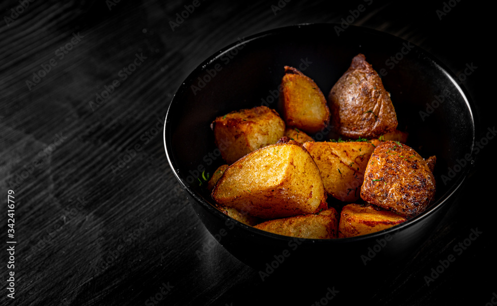 roasted potato in bowl on black wooden table background