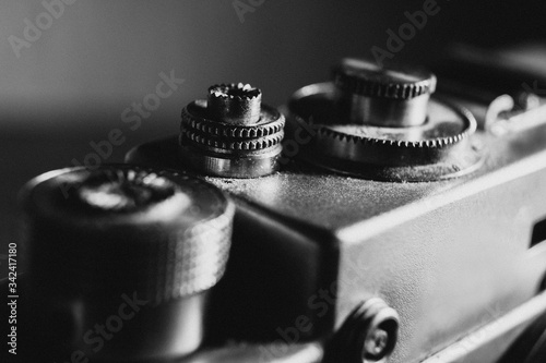 shutter button of an old camera, black and white photo with noise