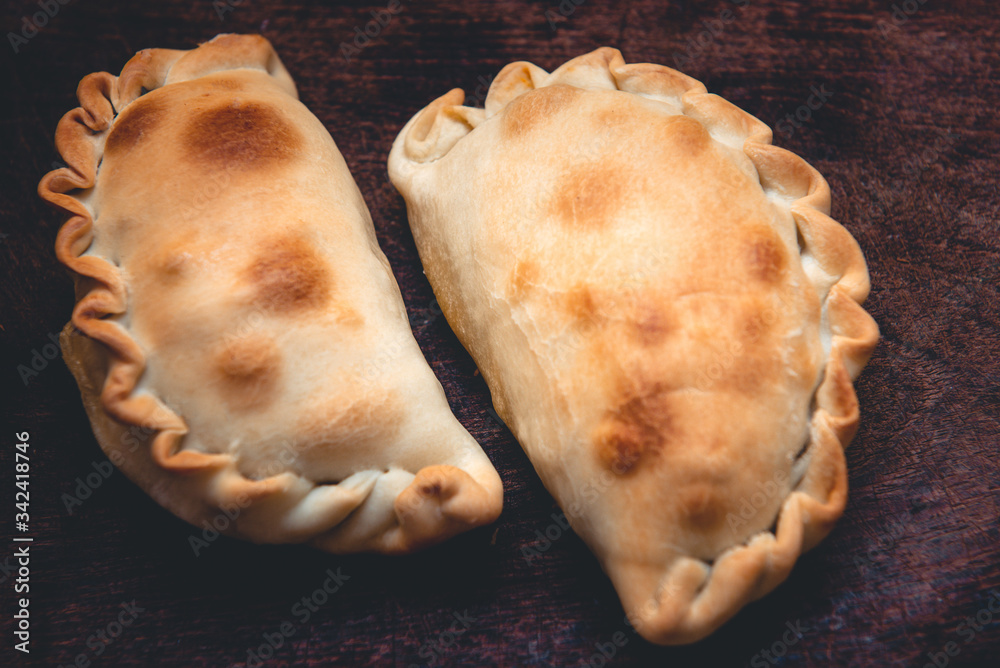 La tradicional empanada de carne argentina, sus ingredientes, como primer plano sobre una tabla de madera rústica. La tradicional empanada de carne argentina, sus ingredientes, como primer plano sobre una tabla de madera rústica.