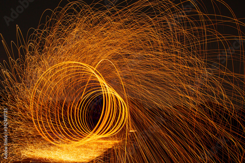 Image playing fireworks by rotating the wave shape of the lines, sparks to light. Amazing Fire Dance in the middle basin slope and beautiful reflection with copy space