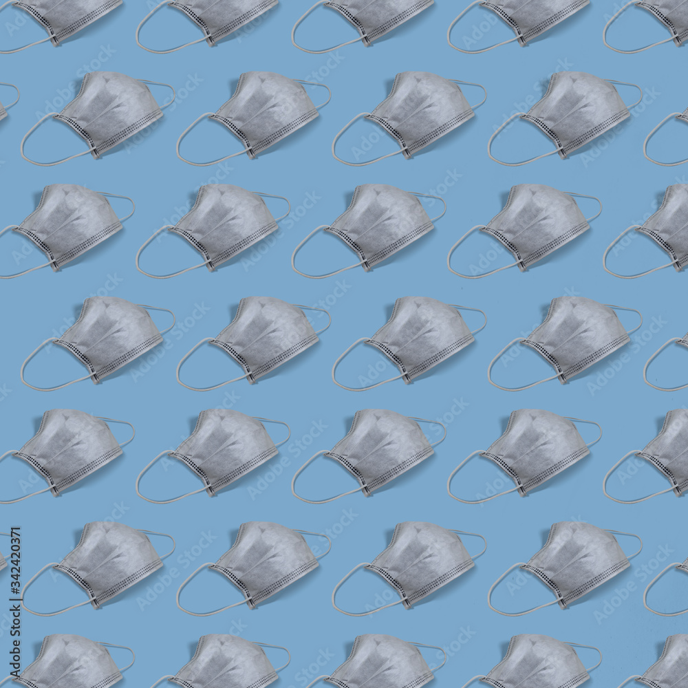 Many protective white face masks to prevent fast spreading coronavirus, repeating pattern on blue background, square. Many protective white face masks to prevent fast spreading coronavirus, repeating pattern on blue background, square.