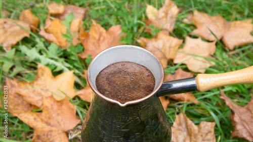 Brewing coffee in a turkish pot - outdoors over the autumn leaves
 photo