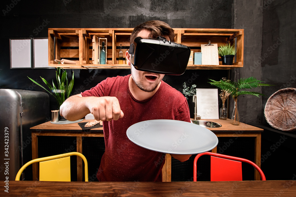 Fotografie Young handsome guy dieting with virtual reality glasses