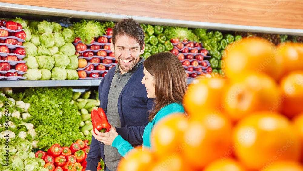 Obraz premium Couple shopping as a consumer while having vegetables