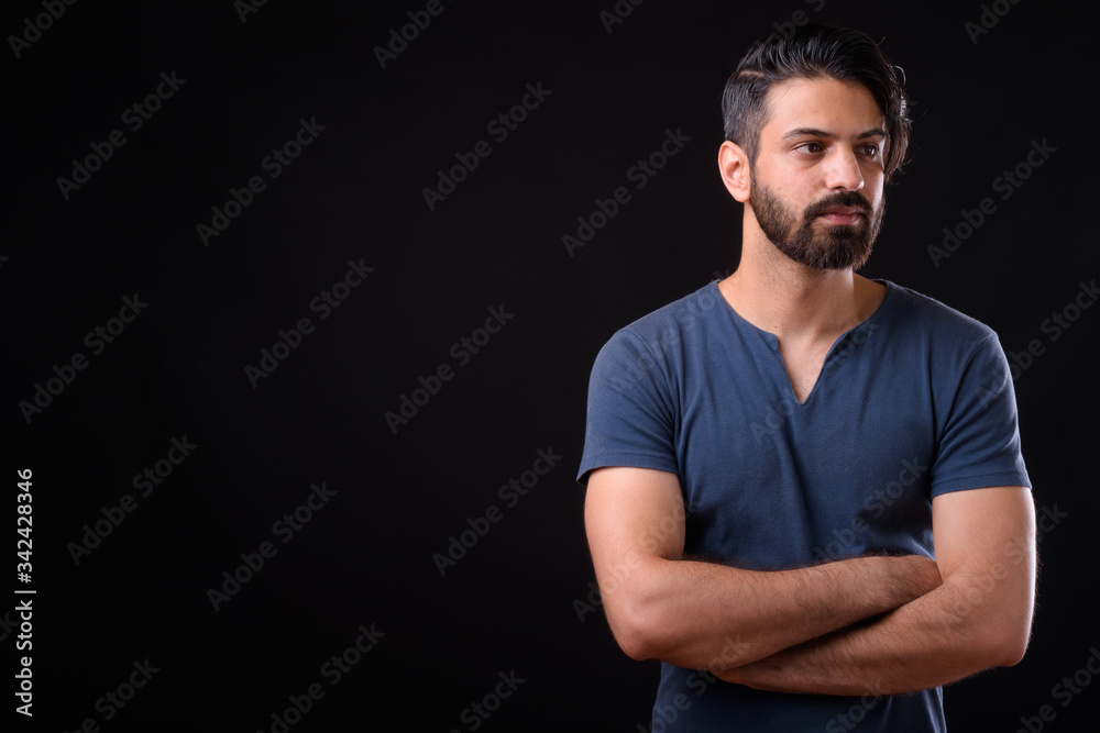 Portrait of handsome bearded Persian man thinking with arms crossed Portrait of handsome bearded Persian man thinking with arms crossed