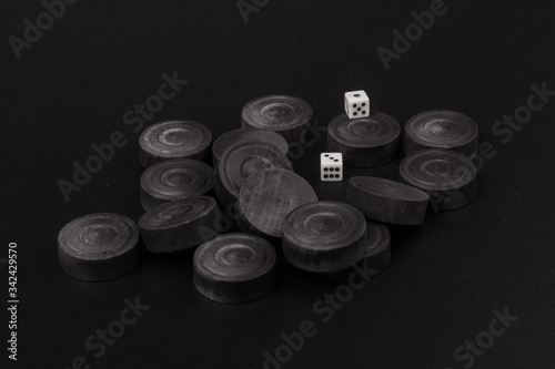 Backgammon. Board game. Black chips for playing on  black background. Game for recreation