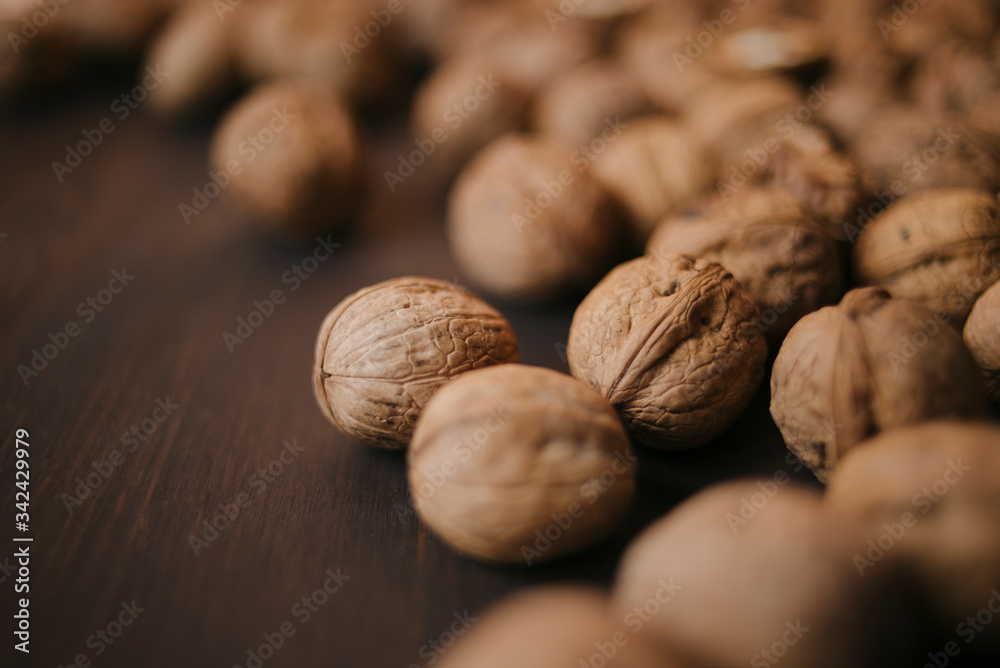 Walnuts with and without shells (filling the picture). Background of fresh walnuts. Walnut kernels on a dark table with color background Walnuts with and without shells (filling the picture). Background of fresh walnuts. Walnut kernels on a dark table with color background