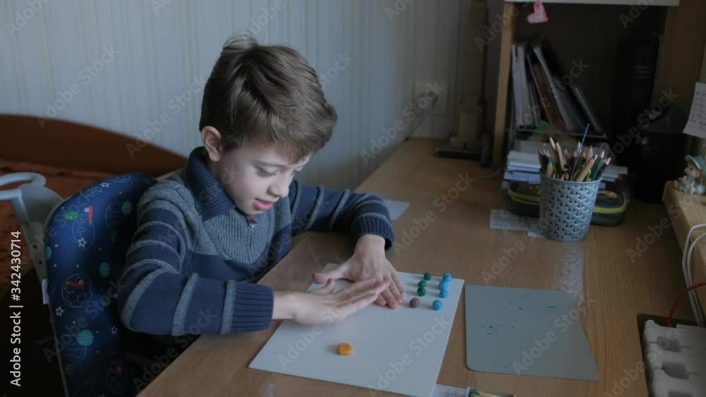 Boy does homework from plasticine. Schoolboy models geometric shapes from matches and plasticine. Boy does homework from plasticine. Schoolboy models geometric shapes from matches and plasticine.