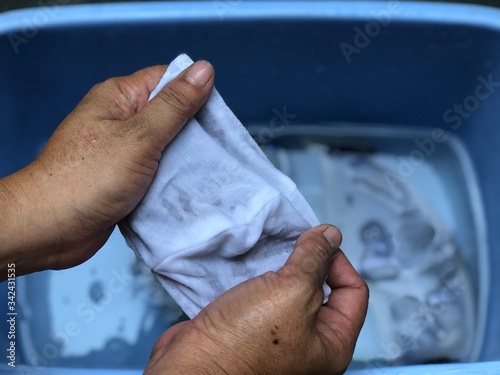 Cotton cloth mask soak in blue tank after the used and washing,natural glare light,the mask repeated use 2-3 times,after use every day should wash and dry in the sun to be sterilized as well.