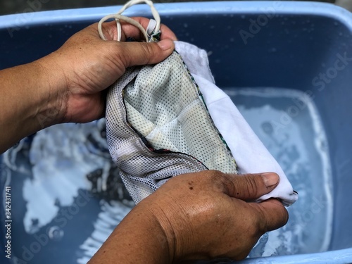 Cotton cloth mask soak in blue tank after the used and washing,natural glare light,the mask repeated use 2-3 times,after use every day should wash and dry in the sun to be sterilized as well.