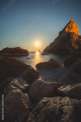 night landscape in costa brava spain, moonrise and rocky seashore