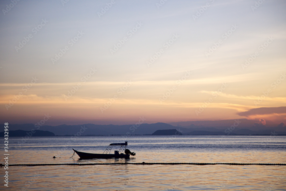 The silhouette of a boat at the sunset. Coast of the Perhentian Besar island, Malaysia, Asia. Travelling.