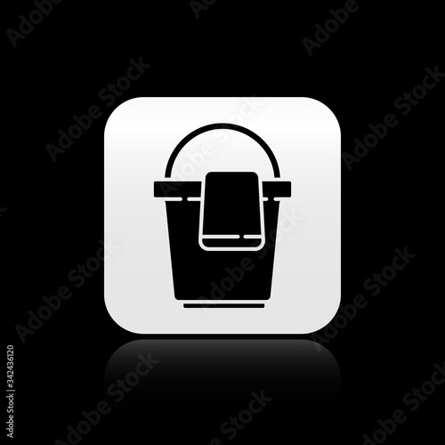 Black Bucket with rag icon isolated on black background. Cleaning service concept. Silver square button. Vector Illustration