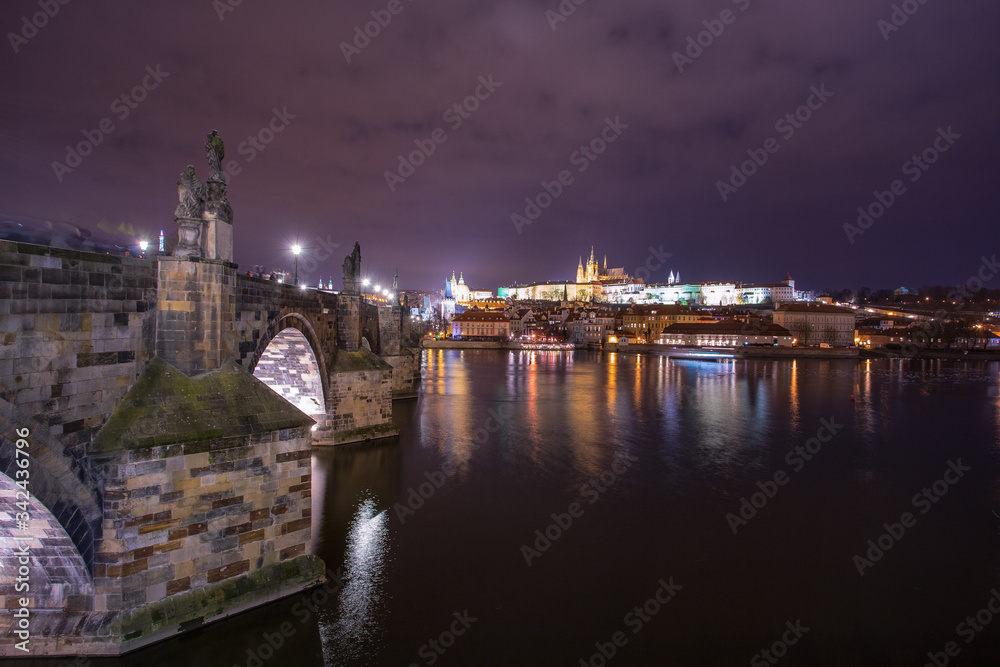 night landscape on Charles bridge in Prague, sculptures and the old town