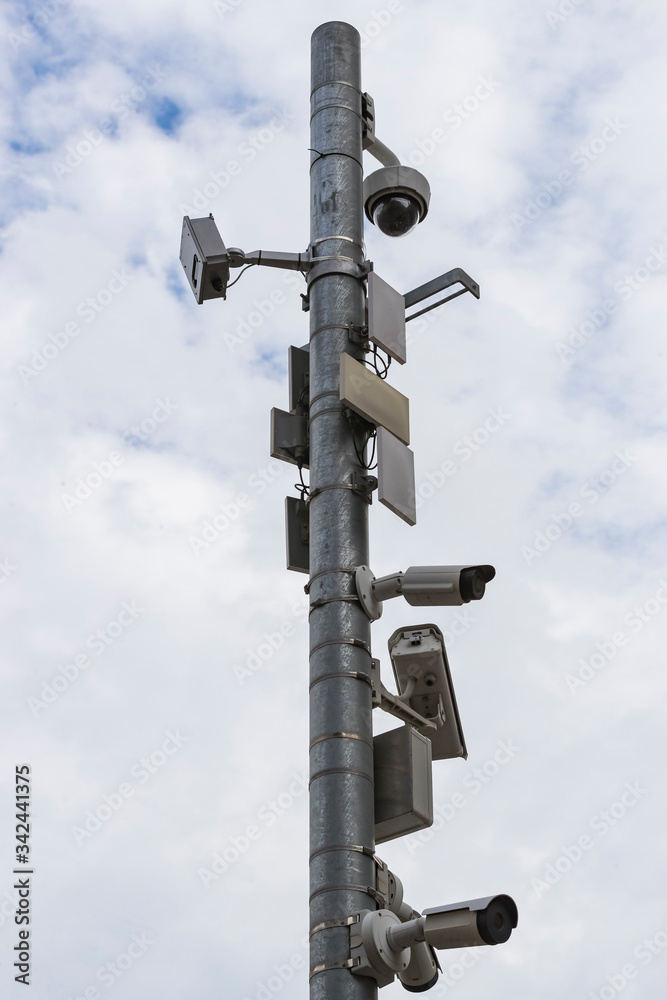 A group of surveillance cameras on a gray sky background.