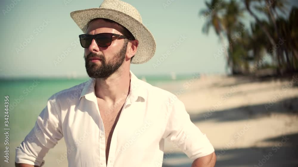 Beautiful Tanned Man In Hat Healthy Skin Sunbathing Enjoy Ocean Vacation.Happy Businessman Enjoying Tropical Resort Hotel.Handsome Man Walking On Tropical Beach.Guy Relaxing On Caribbean Sea Beach. Beautiful Tanned Man In Hat Healthy Skin Sunbathing Enjoy Ocean Vacation.Happy Businessman Enjoying Tropical Resort Hotel.Handsome Man Walking On Tropical Beach.Guy Relaxing On Caribbean Sea Beach.