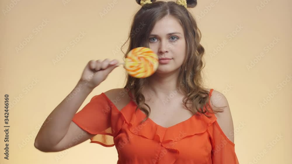 funny pretty girl with caramel candy on colored studio background, young happy woman posing with sweet lollipop, concept food, mood and style funny pretty girl with caramel candy on colored studio background, young happy woman posing with sweet lollipop, concept food, mood and style