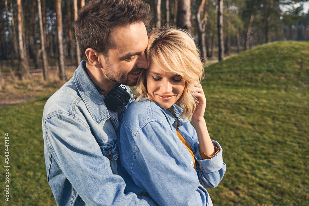 Fototapeta premium Joyous good-looking loving young couple standing outside