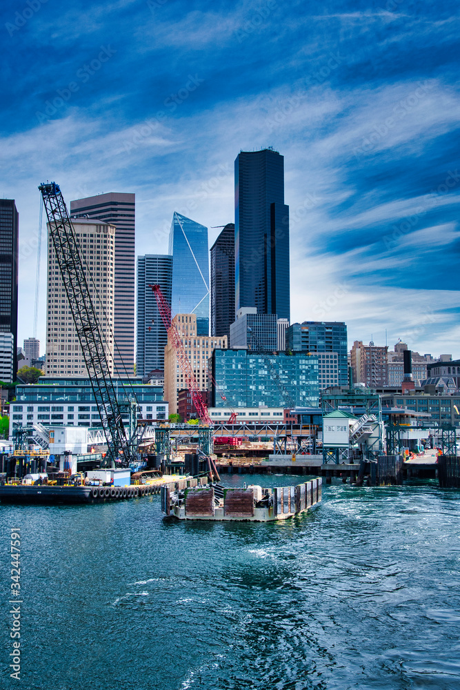 Fototapeta premium 2020-04-23 THE OLD AND NEW COLEMAN DOCK IN DOWNTOWN SEATTLE WITH THE CITY SKYLINE AND A BRIGHT BLUE SKY