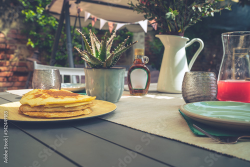 Breakfast time. Delicious sweet pancakes on a table in the garden 