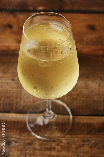 A glass of white wine on a wooden table