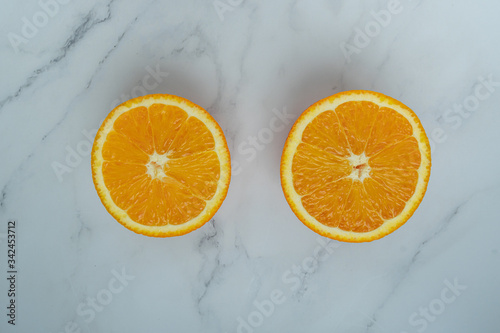 slices of ripe orange fruits isolated on white marble background. top view. Juicy and sweet and renowned for its concentration of vitamin C