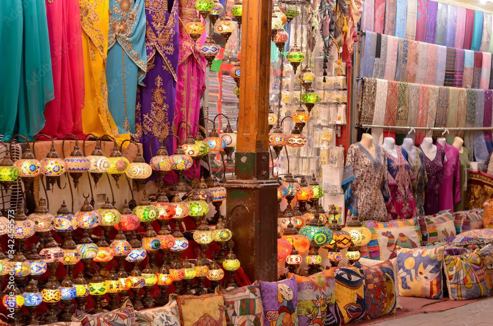 Traditional Turkish Lamps / lanterns, Ottoman Lights, Mosaic Chandeliers, pillow / cushion covers, kaftan, salwar kameez on display in a handicraft pawn shop in Dubai, UAE during Ramadan month.