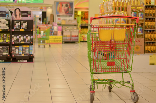 Shopping carts in a modern hypermarket store in a mall. The POS impulse products are clearly visible as people/customers are seen moving in FMCG area of the retail store