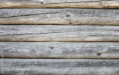 Background of aged rounded natural wood log house wall of a timber wooden house texture