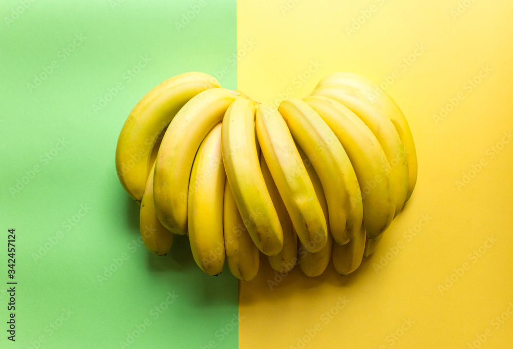 beautiful, fresh, bunch of yellow bananas on the yellow background. Concept of fresh food. Fruits offers as advertising or web background. Free copy space. Top view beautiful, fresh, bunch of yellow bananas on the yellow background. Concept of fresh food. Fruits offers as advertising or web background. Free copy space. Top view