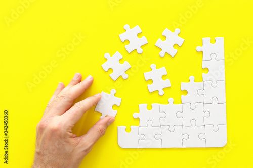 male hand putting the last piece in the puzzle