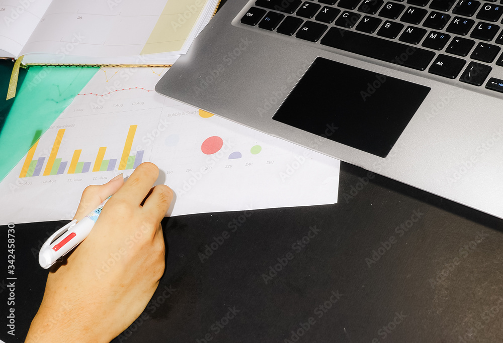Woman working and writing on graph paper and notebook Woman working and writing on graph paper and notebook