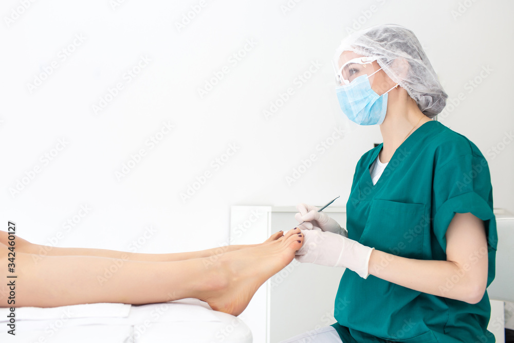 Master during a pedicure. The process of professional pedicures. The master is talking to a female client. The concept of beauty and health. Copy space Master during a pedicure. The process of professional pedicures. The master is talking to a female client. The concept of beauty and health. Copy space