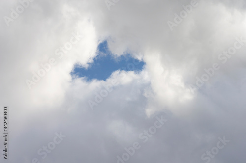 Thick clouds in the blue sky. Background photo of clouds where the sun shines through.