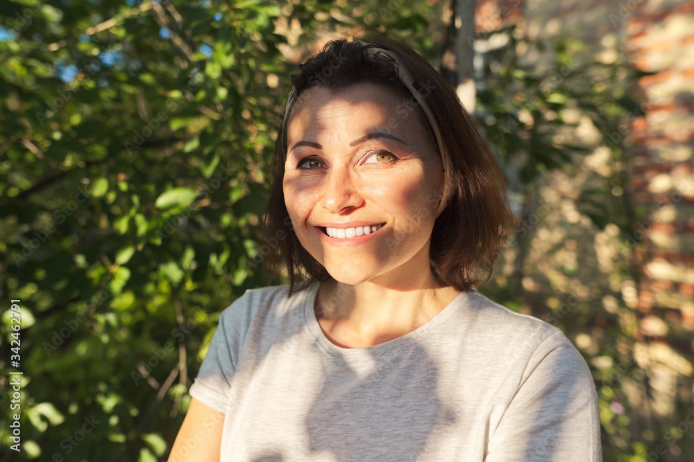 Portrait of mature smiling woman in garden near house Portrait of mature smiling woman in garden near house