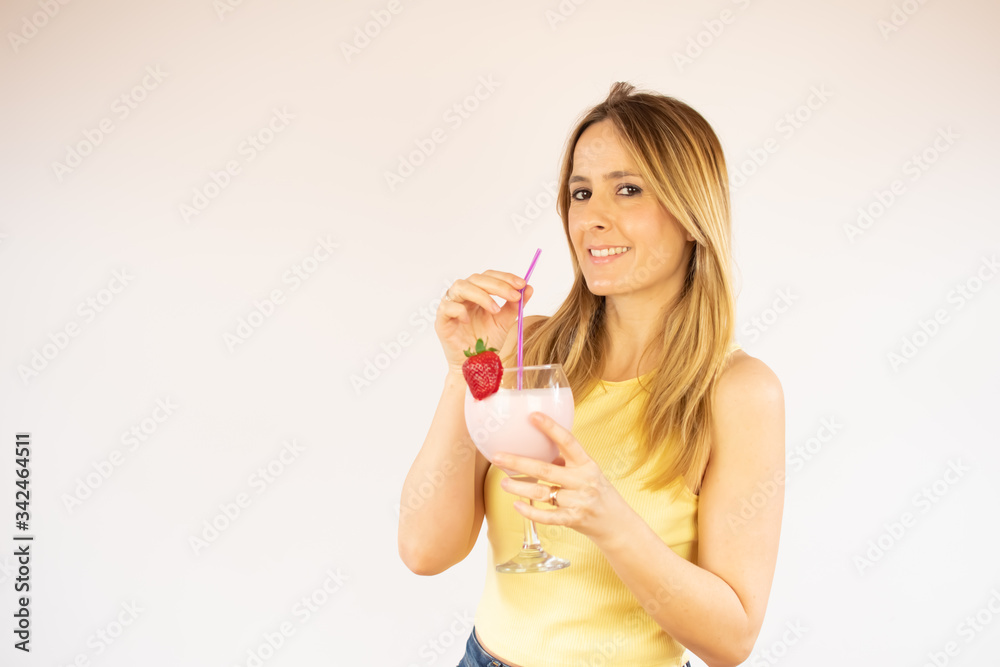 Pretty woman smiling having a strawberry smoothie Pretty woman smiling having a strawberry smoothie
