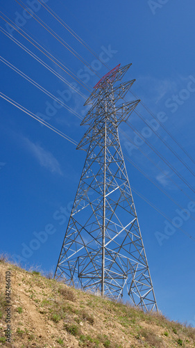 High voltage electrical tower. Electric poles in front of blue sky.