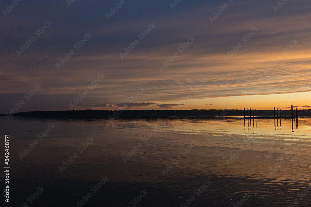 sun setting over a long fishing dock