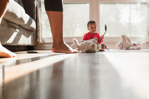 Baby playing with pots and pans at home furing quarantine copyspace