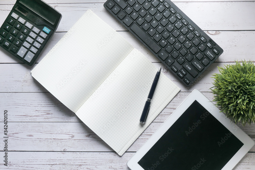  notepad , pen , calculator, keyboard and digital tablet on table 