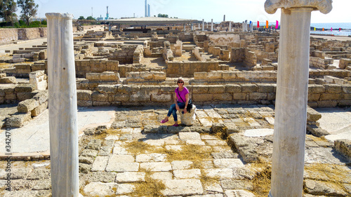 Caucasian middle-aged woman sitting amongst ruins, Caesarea, Israel © Danielle