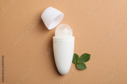 Bilde på lerret Body antiperspirant deodorants roll-on and leaves on brown background, space for