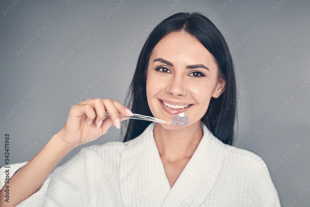 Happy Caucasian young female brushing her teeth Happy Caucasian young female brushing her teeth