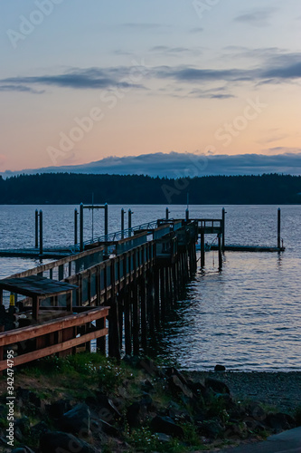 sun setting over a long fishing dock