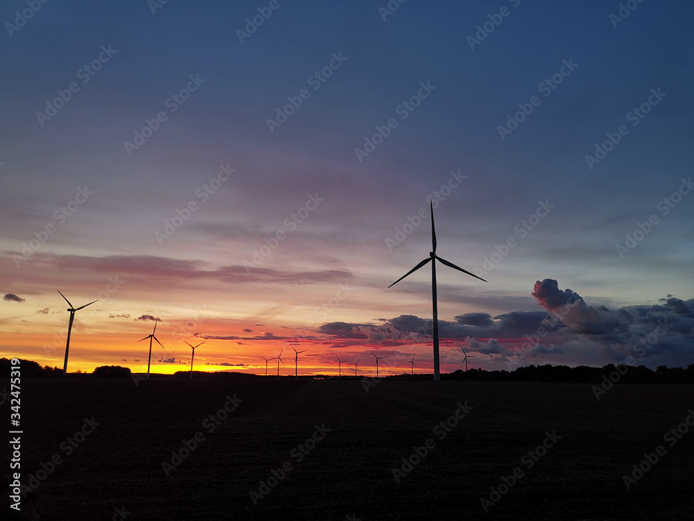 Obraz premium Silhouette of windturbines on an amazing sunset.
