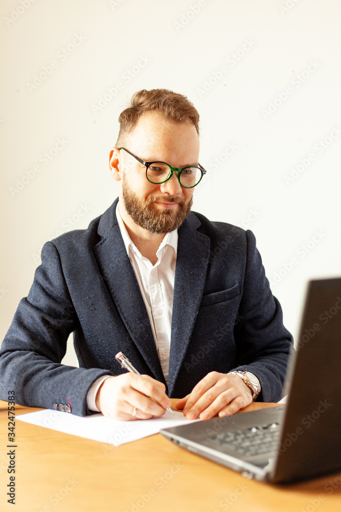 a man in a suit works from home with a laptop computer a man in a suit works from home with a laptop computer